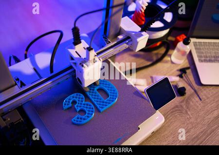 3D Printer Creating Blue Letters Stock Photo