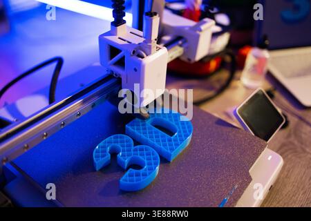 3D Printer Creating Blue Letters Stock Photo