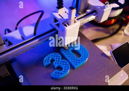 3D Printer Creating Blue Letters Stock Photo