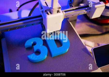 3D Printer Creating Blue Letters Stock Photo