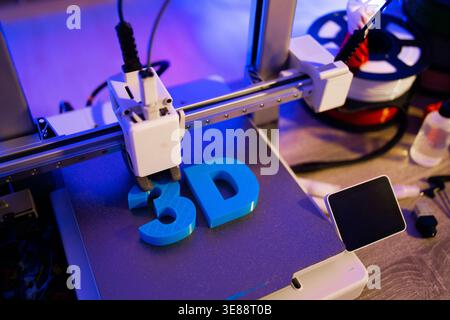 3D Printer Creating Blue Letters Stock Photo