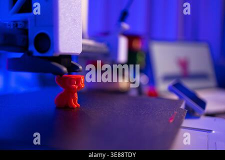 3D Printer Creating Red Cat Figurine Stock Photo