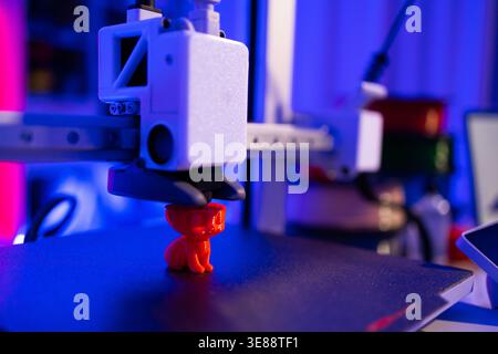 3D Printer Creating Red Cat Figurine Stock Photo