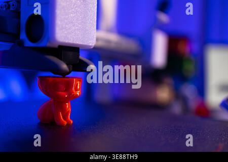 3D Printer Creating Red Cat Figurine Stock Photo
