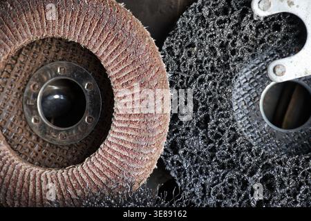 Detailed view of two different types of grinding and stripping discs, one made of abrasive material and the other a black stripping disc, for use with Stock Photo