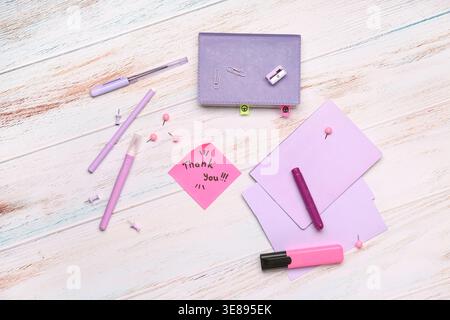 Sticky note with text THANK YOU and stationery on grunge background Stock Photo
