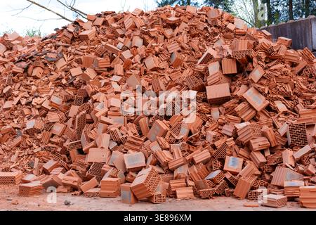 Enormous pile of shattered red clay bricks and perforated ceramic blocks lies at a construction waste recycling facility in Hainstadt, Germany, waitin Stock Photo