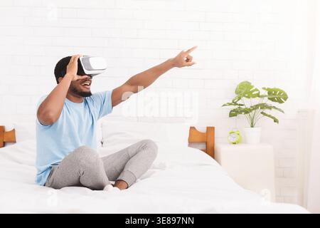 Excited young black man using virtual reality headset Stock Photo