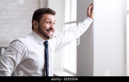 Successful businessman leaning on the wall in office Stock Photo