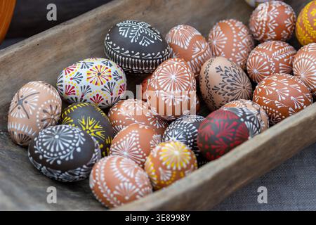Traditional Lithuanian wooden colorful Easter eggs in a wooden basket, symbol of fertility and life painted with the symbols of nature Stock Photo