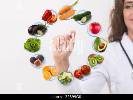 Hand of nutritionist doctor showing pill on symbols fruits Stock Photo
