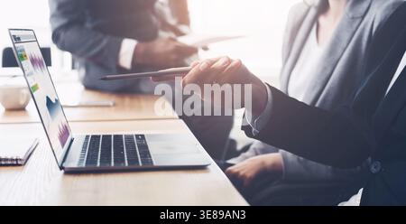 Executives discussing new project on laptop at meeting Stock Photo