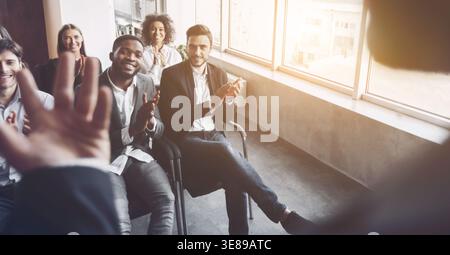 Multiethnic team listening to speaker at meeting Stock Photo