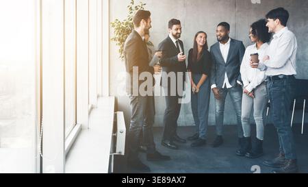 Colleagues talking at coffee break near window Stock Photo