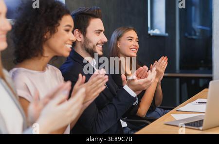 Happy diverse business team applauding at conference Stock Photo
