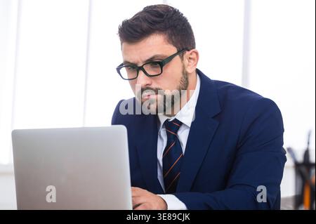 Executive working on laptop, surfing internet in office Stock Photo