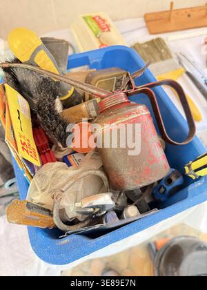 A small metal toolbox accompanied by a red oil can, representing essential maintenance tools used in mechanical repair, DIY work, and workshop environ Stock Photo