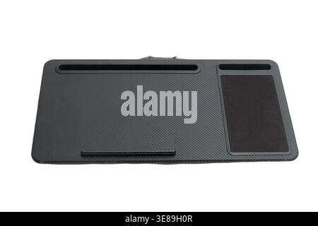 Portable laptop desk with mouse pad area and phone slot. Black ergonomic workstation stand for notebook computer. Accessory surface for remote work on Stock Photo