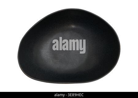 Black ceramic bowl with organic irregular shape. Empty matte stoneware dish for food serving in professional kitchen or restaurant. Modern minimalist Stock Photo