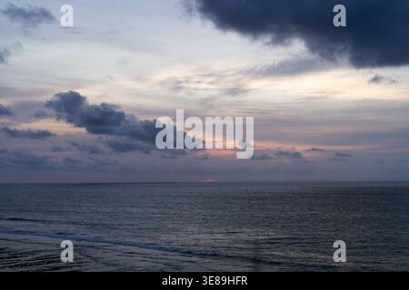 Overcast sky with dramatic clouds over calm ocean at Balangan Beach Stock Photo
