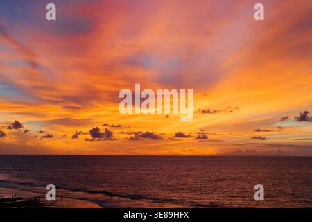 Intense fiery orange sunset sky over ocean at Balangan Beach, Jimbaran Stock Photo