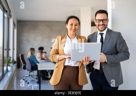 Two happy diverse multiethnic business team people working, talking in corporate office Stock Photo