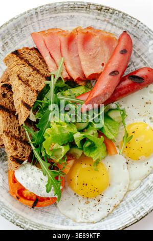 breakfast on a plate with sausages, eggs, cereal and salad Stock Photo