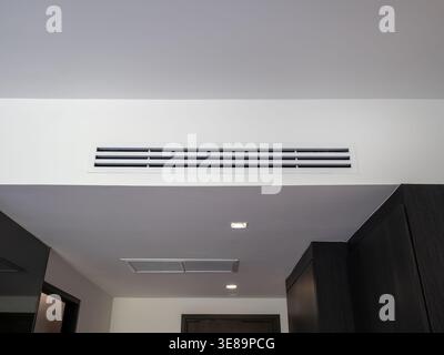 Modern air conditioning vent installed on ceiling in hotel bedroom, representing HVAC system, indoor air circulation, cooling technology, ventilation Stock Photo