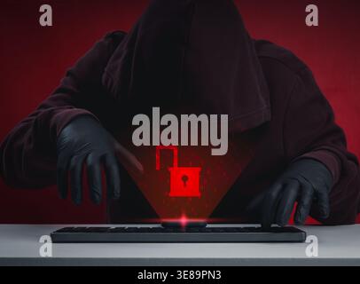 Cyber attack concept with hooded hacker and glowing unlocked padlock on smartphone. Data breach, system hacked, identity theft, and cybersecurity thre Stock Photo