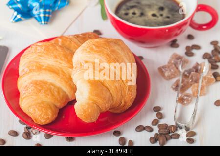 Fresh croissants with cup of hot coffee on white wooden background Stock Photo