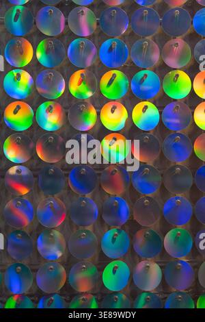 Glitter background, abstract, shiny circles wall multi-colored bright twinkles and shadows. Glowing metal shimmering fabric texture close up. Sparkling sequined textile. Event decoration on photo zone Stock Photo