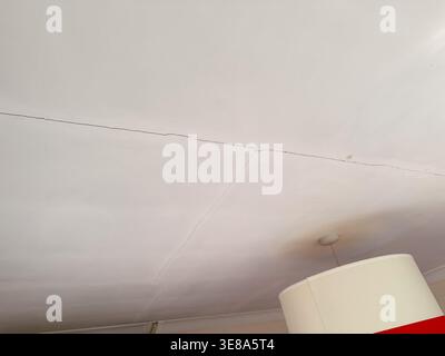 Interior of a UK house showing damage caused by flooding, with water-stained walls, soaked flooring, and signs of material deterioration. Stock Photo