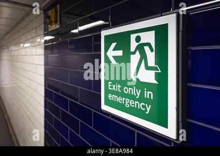 Emergency exit sign in an underground corridor Stock Photo