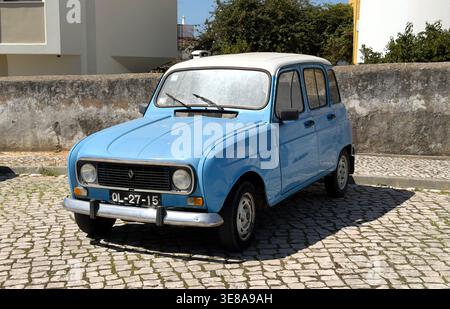 Vintage light blue Renault 4 parked on a traditional cobblestone street in Portugal with a white roof and classic chrome bumper Stock Photo