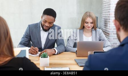 Hr managers interviewing job applicants, making notes Stock Photo