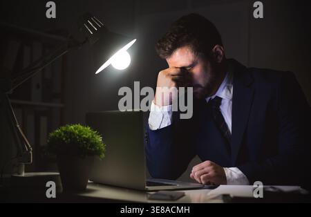 Stressed businessman working on laptop, having problems Stock Photo