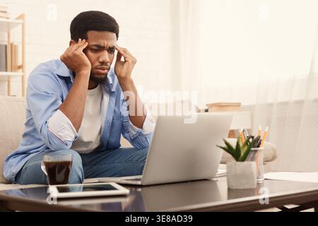 Concentrated black man analizing information on laptop Stock Photo