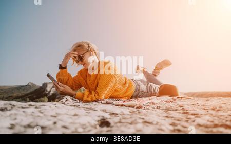 Young Woman Relaxing on a Mountaintop with Phone Stock Photo