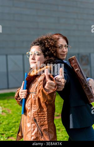 Diverse businesswomen giving thumbs up for success and teamwork Stock Photo