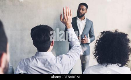 Businessman raising his hand, having question, crop Stock Photo