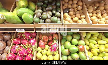 Toronto, ON, Canada - March 14, 2026: An assortment of fresh and colorful tropical fruits are displayed in wooden crates at a grocery store. Stock Photo