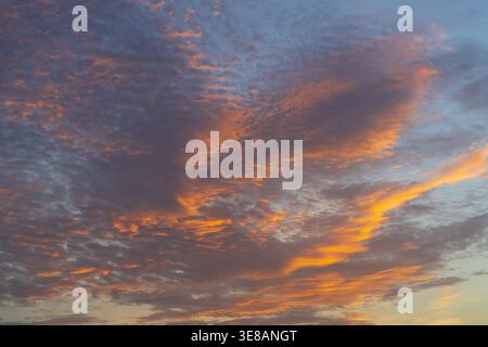 The sky is painted with fiery orange and soft purple hues as the sun sets, creating a breathtaking natural spectacle Stock Photo