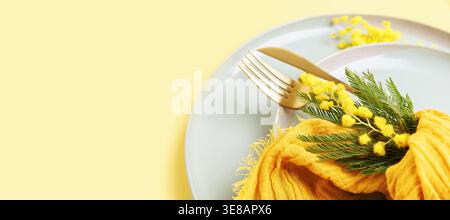 Romantic spring table decor with mimosa and ceramic plates Stock Photo