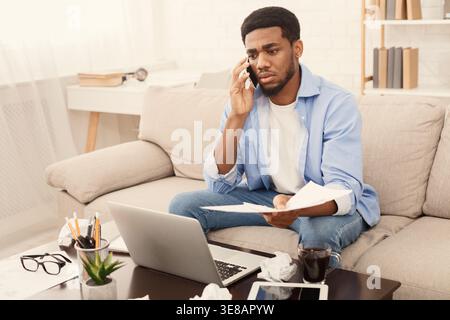 Serious man talking on phone and reading document Stock Photo