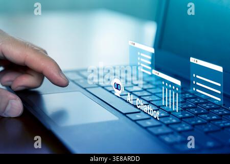 Close view of a hand using a laptop with a holographic AI chatbot interface, ideal for customer support, virtual assistance, automation, online commun Stock Photo