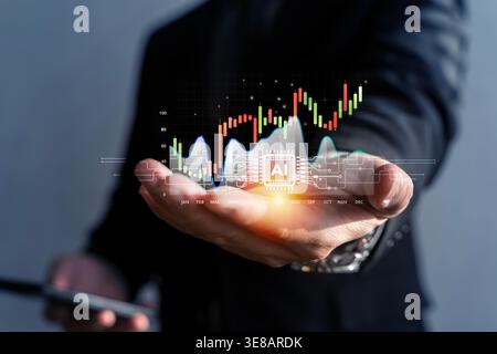 A business hand presents a glowing AI chip with market chart overlays and a smartphone, illustrating stock analysis, fintech innovation, predictive tr Stock Photo