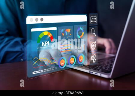 A professional works on a laptop with a floating KPI dashboard, visualizing business metrics, performance analysis, reporting, and data-driven decisio Stock Photo