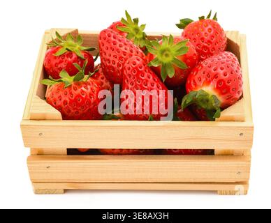 Wooden crate filled with fresh ripe strawberries, isolated on a white background. The image highlights the natural , vibrant red color, and freshness Stock Photo