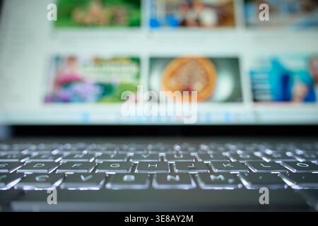 Close up of laptop keyboard with blurred screen in background. Concept of digital technology, online browsing and modern computer use Stock Photo