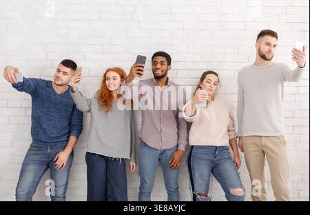 Young people taking selfies on their smartphones Stock Photo